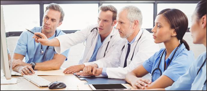 Doctors and medical professionals collaborating and reviewing design plans on a computer screen, illustrating the process of product custom development and design for medical devices, from needs analysis to final product optimization